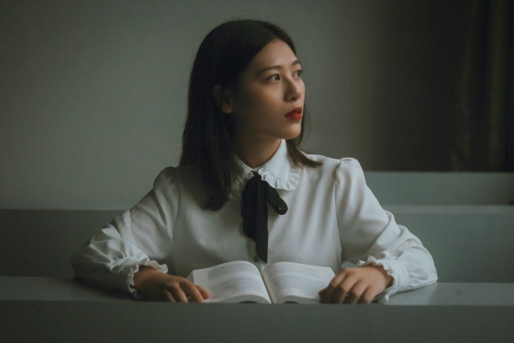 a woman sitting at a table with an open book